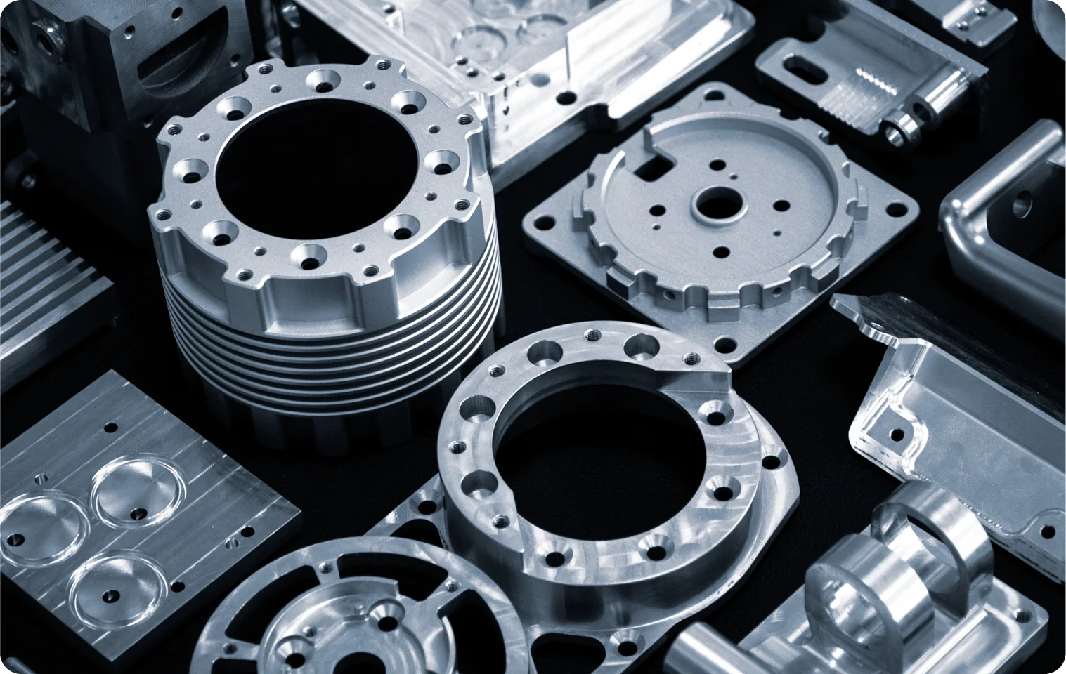 Precision-machined aluminum and titanium components laid out on a dark surface